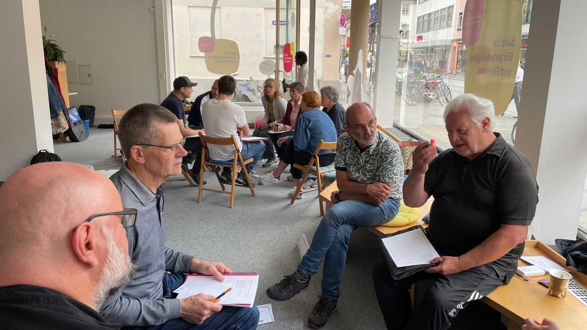 Menschen sitzen in Kleingruppen zusammen