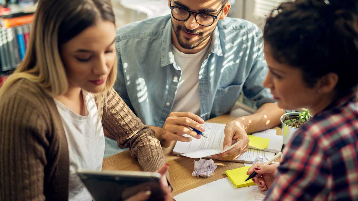Schatzmeister-Austausch drei Personen sitzen an einem Tisch und schauen auf ein Display